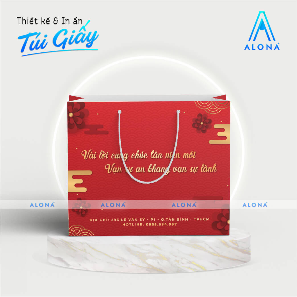 Túi giấy màu đỏ, quai túi dây dù trắng, in câu chúc Tết trang trọng và truyền thống